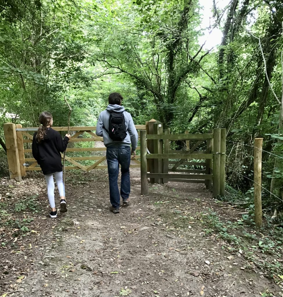 Two people walking in the woods in Castle Combe